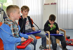 Kinder spielen Melodika